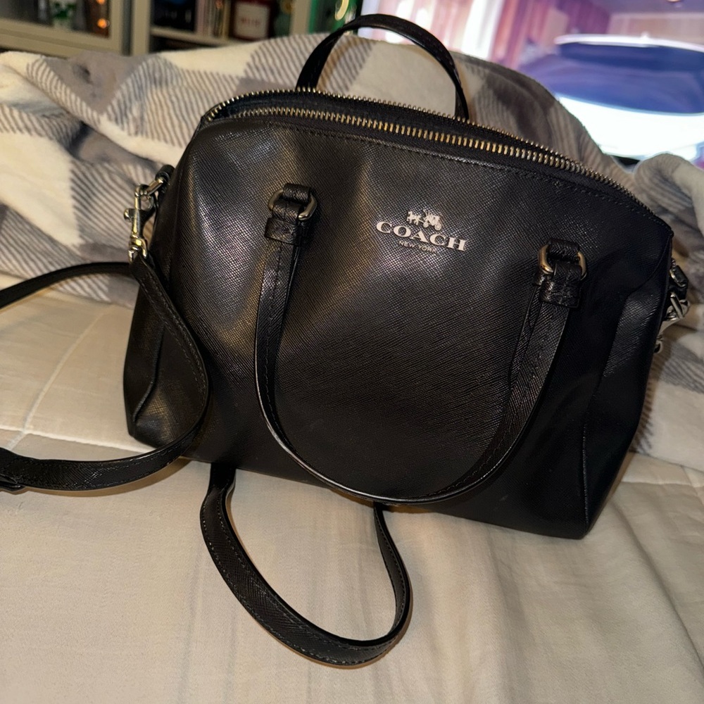 small COACH satchel bag with strap.